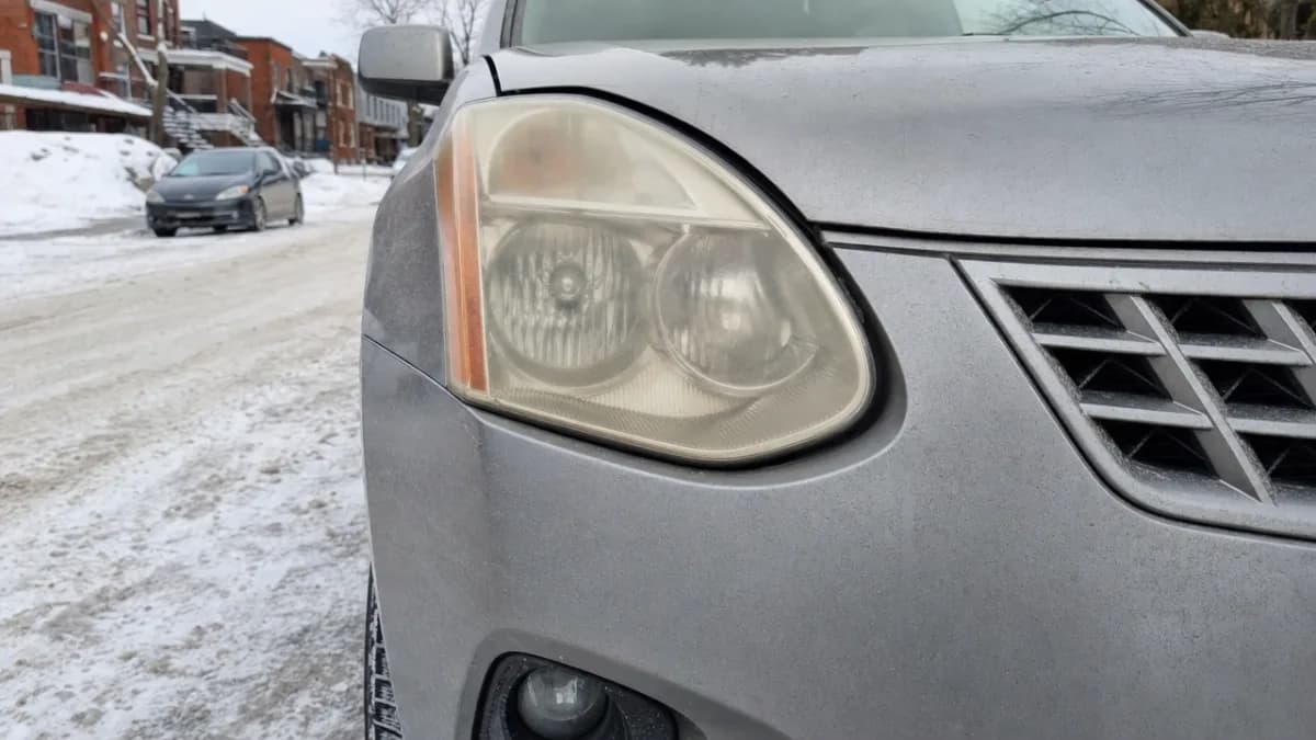 Phares jaunis et opaques d'un Nissan Rogue garé dans une rue de Montréal en hiver